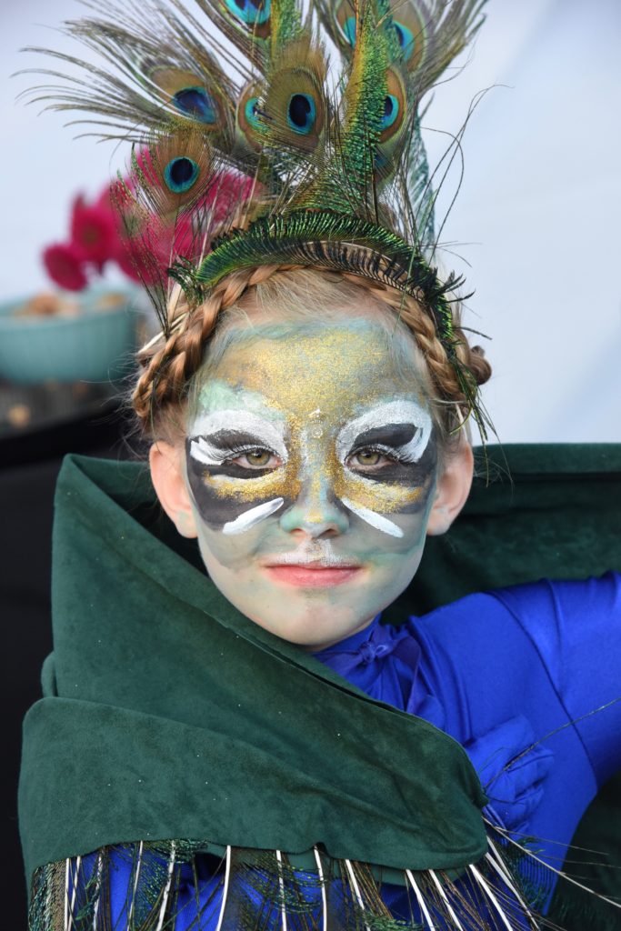 Girl dressed as a peacock for the 2018 Big Sur Fashion Show, a cultural encounter with the spirit of community. (Image © Meredith Mullins.)