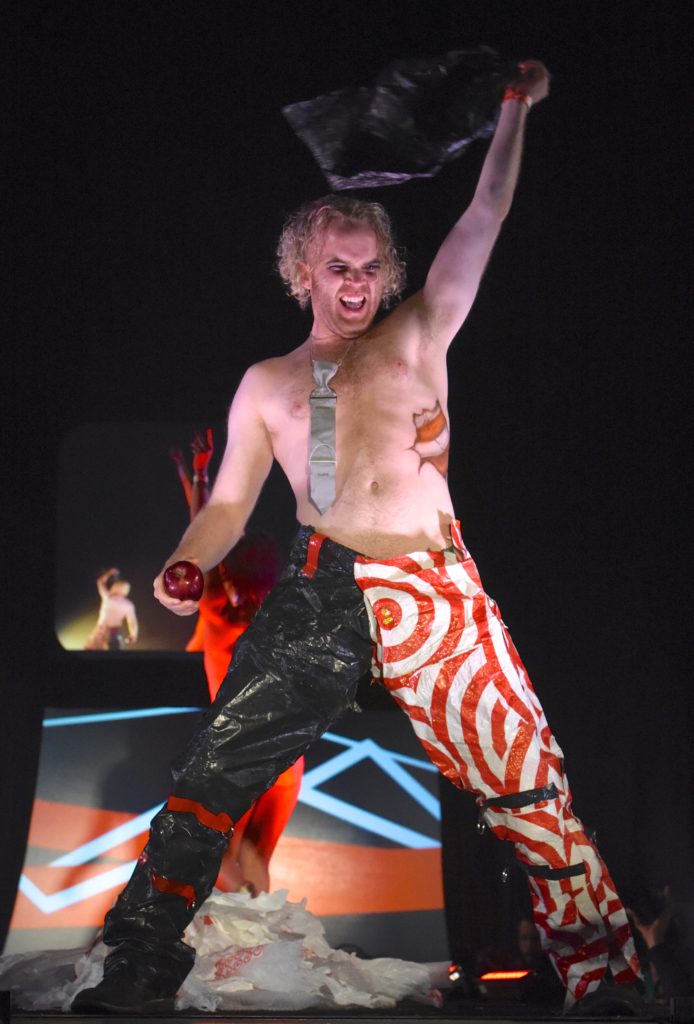 Bare chested man in tie and colorful pants at the 2018 Big Sur Fashion Show, a cultural encounter with the spirit of community. (Image © Meredith Mullins.)