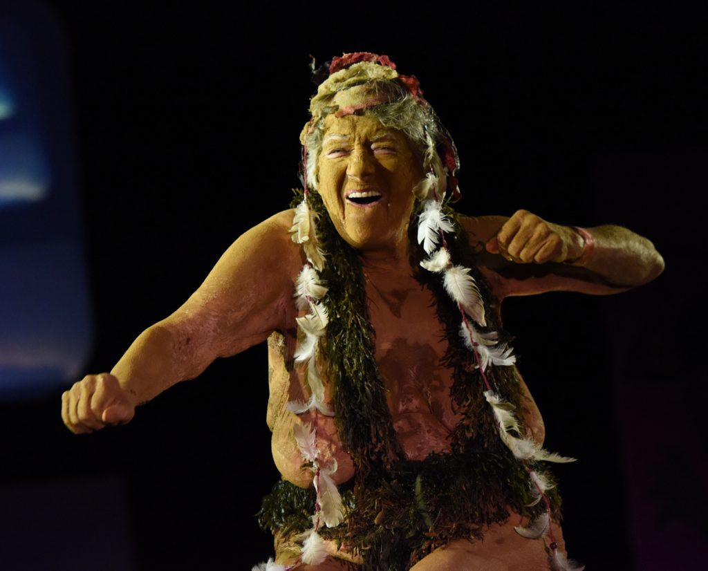 Jocelyne Muson, covered in mud, feathers, and seaweed, shows the spirit of the 2018 Big Sur Fashion Show, a culture encounter with the spirit of community. (Image © Meredith Mullins.)