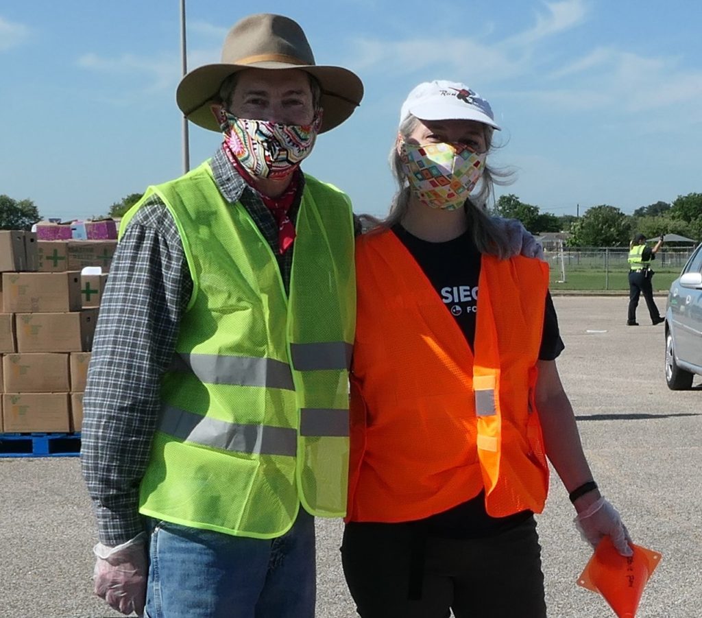 A man and woman in protective masks volunteering at a food bank exemplify Texans’ cultural tradition of helping one's community during a crisis. (Image © Kathryn Rogers)